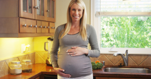 Beautiful pregnant woman standing in kitchen